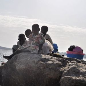 Kids resting on a rock on the shores of Lake Victoria. #TembeaKenya.